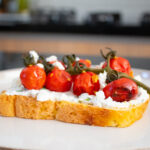 Toast de ricotta con arúgula y jitomates cherry